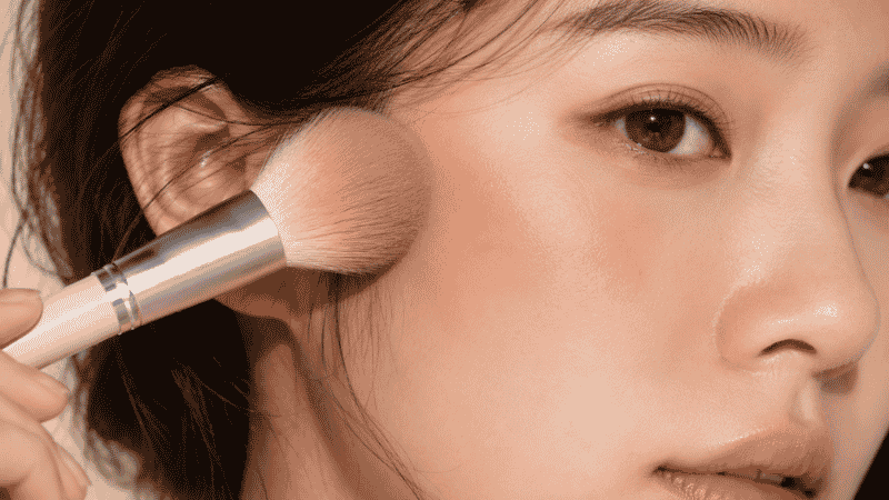 Finger tapping cream blush onto cheek for a natural skin-like flush