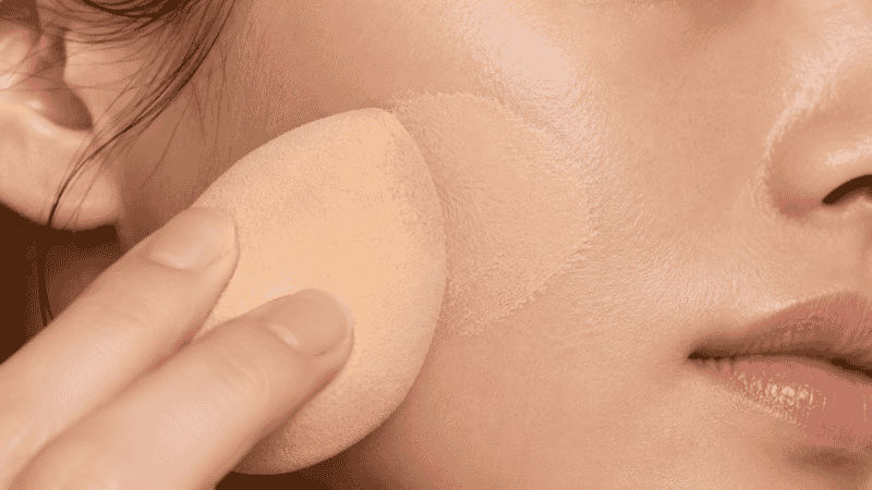 Damp beauty sponge bouncing liquid foundation onto skin for a natural seamless finish