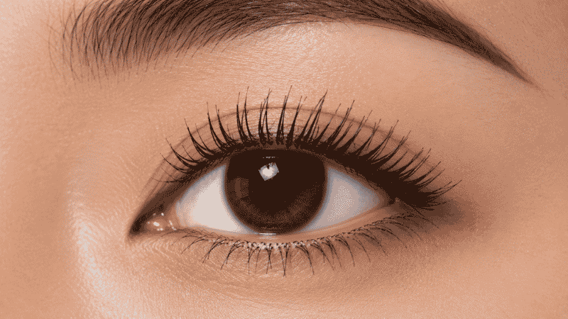 Two mascara coats being built up on lashes showing volume and length progression
