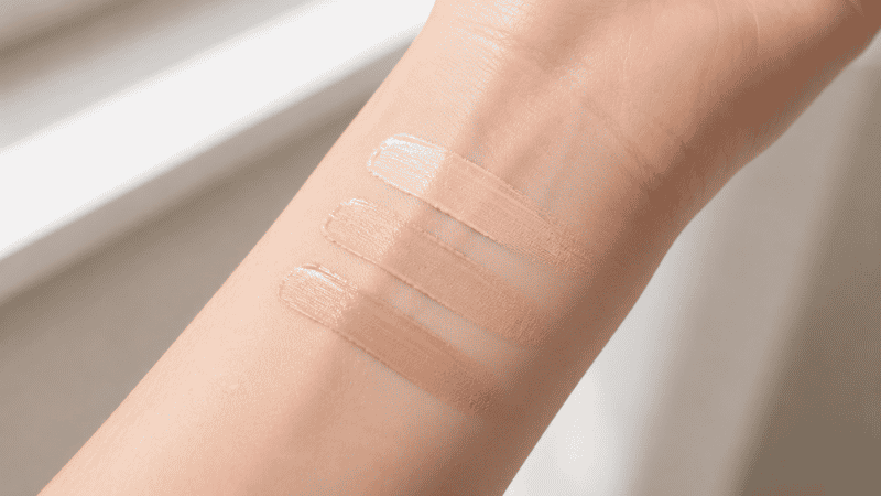 Three concealer shades swatched on inner wrist in natural light for shade matching