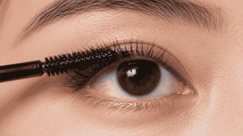 Mascara wand placed at the root of upper lashes with a wiggling motion to separate and coat lashes