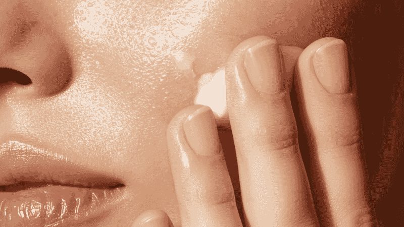 Moisturizer being pressed into slightly damp skin immediately after serum to lock in hydration
