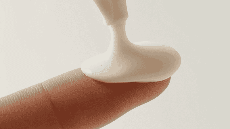 Creamy milky cleanser being dispensed onto fingertips showing non-stripping gentle formula for dry skin