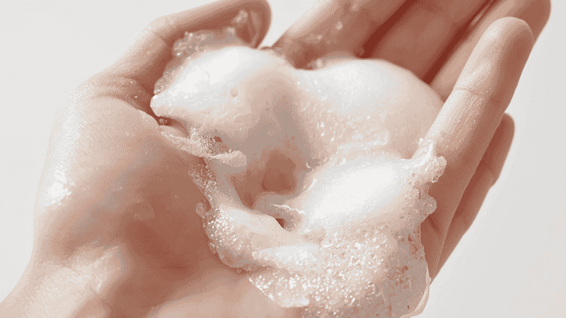 Gentle foaming cleanser being lathered on hands showing soft non-stripping foam for oily skin