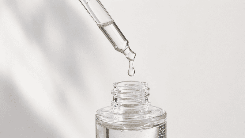 Small dropper bottle of niacinamide serum being applied to face before moisturizer for combination skin