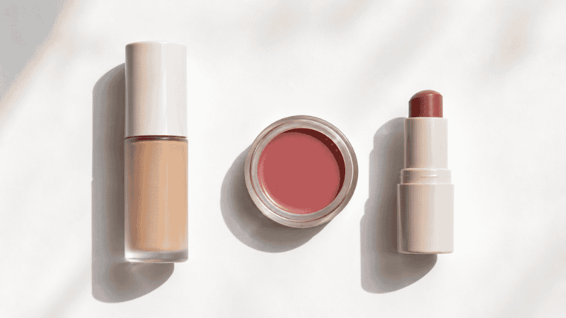 Three minimal makeup products — skin tint cream blush and tinted lip balm — for a five-minute everyday routine