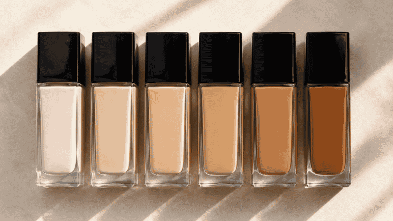 Row of drugstore foundation bottles showing a wide shade range from fair to deep for beginners