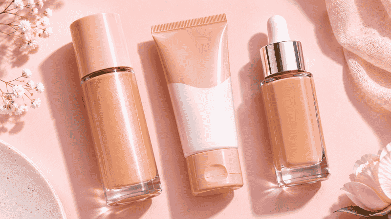 Three affordable drugstore tinted moisturizer and BB cream products arranged on a pink surface under $15