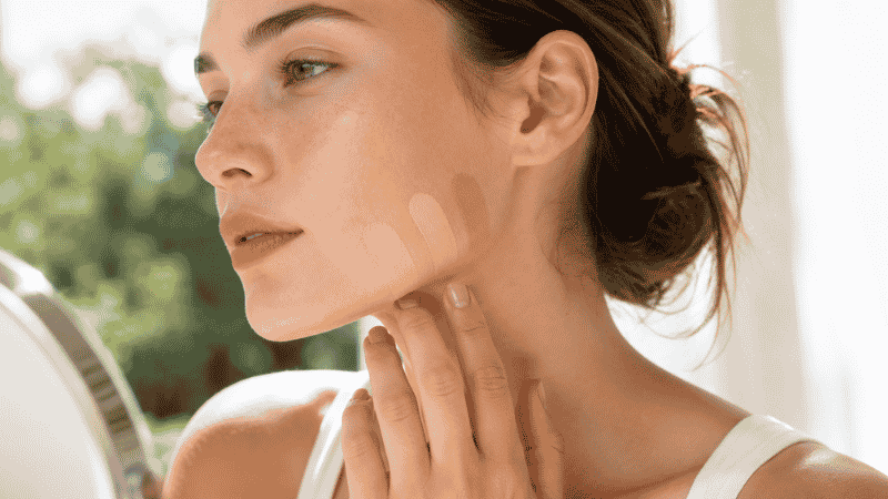 Foundation shade swatches applied along the jawline being checked in natural outdoor light for accurate color matching