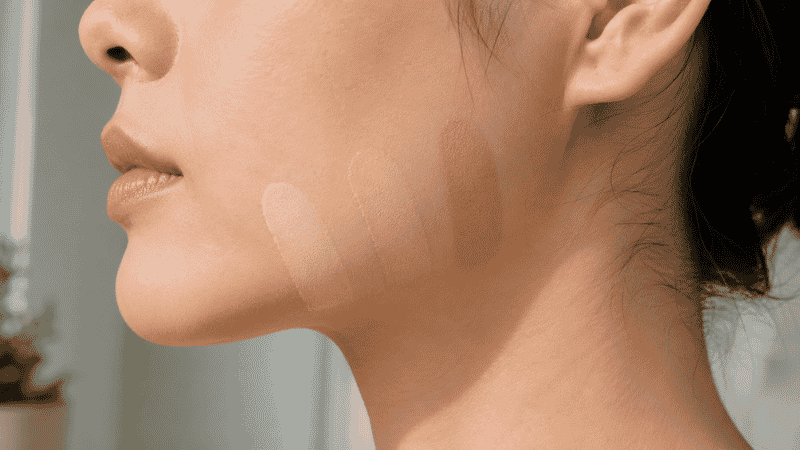 Three foundation shade swatches in different depths tested on a jawline in natural light for shade matching