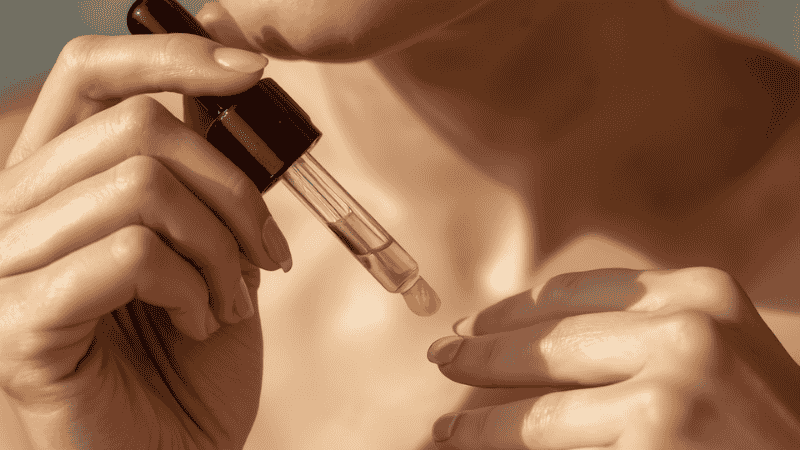 A woman applying a small drop of botanical serum to her inner wrist for a safety patch test to prevent irritation from new skincare products.