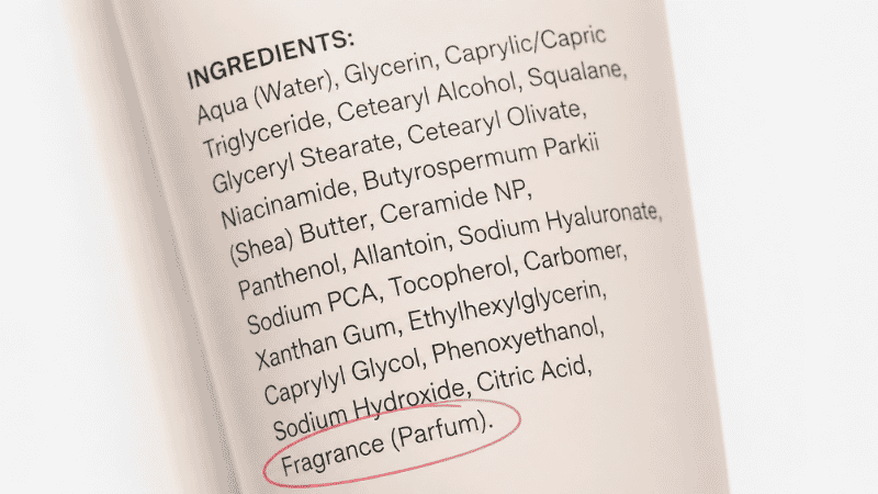 Close-up of a makeup product ingredient label with fragrance and parfum highlighted as common skin irritants