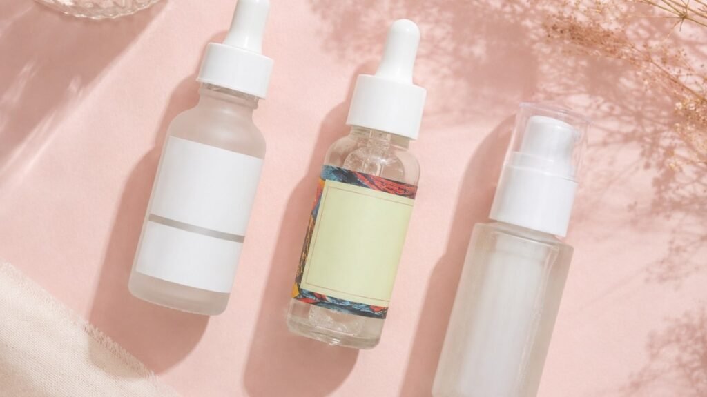Three affordable niacinamide serum products arranged on a pink surface showing budget-friendly dark spot treatment options